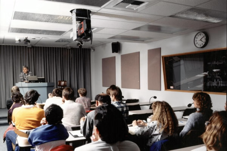 Students attend a lecture in a classroom using distance learning technology.