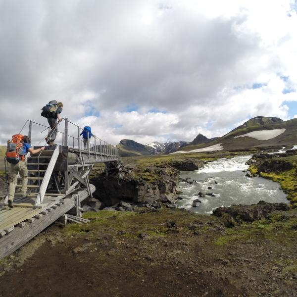 Students hiking over bridge in Iceland
