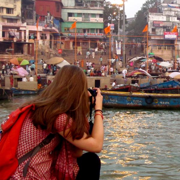 Woman taking photo of boats by a river