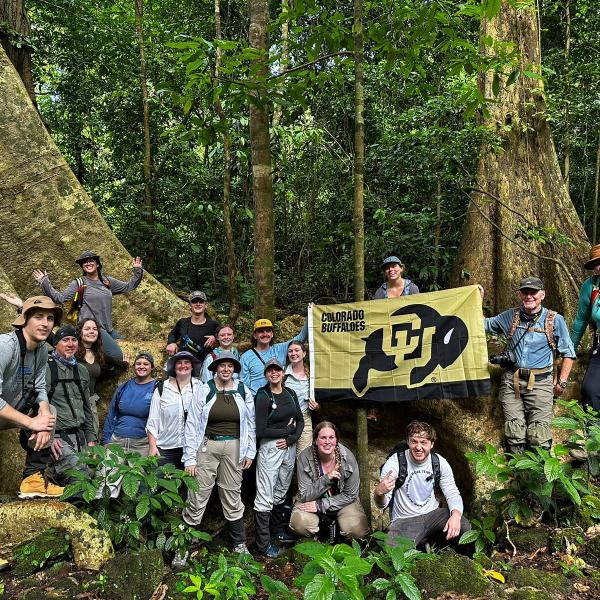 Group of CU students with CU flag in Vietnamese forest