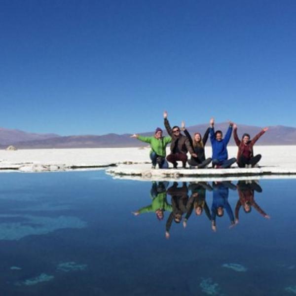 Students with hands raised by lake in Chile