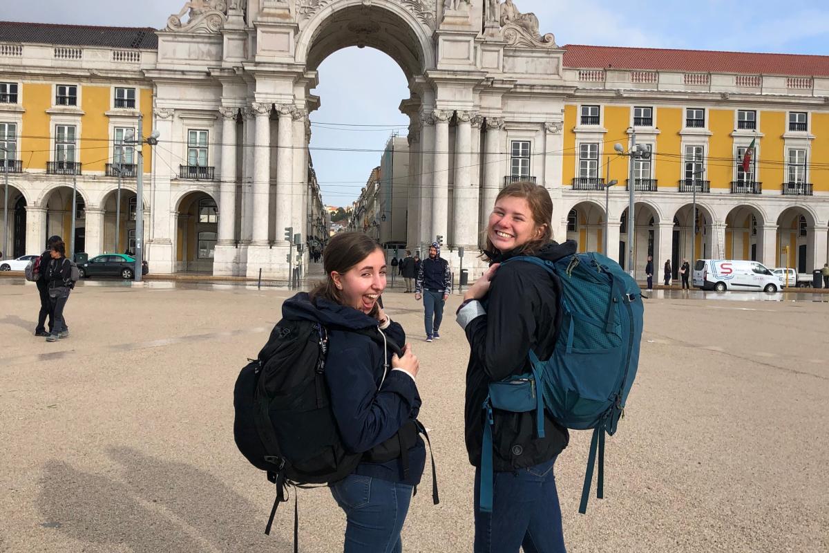 Students wearing backpacks in a plaza