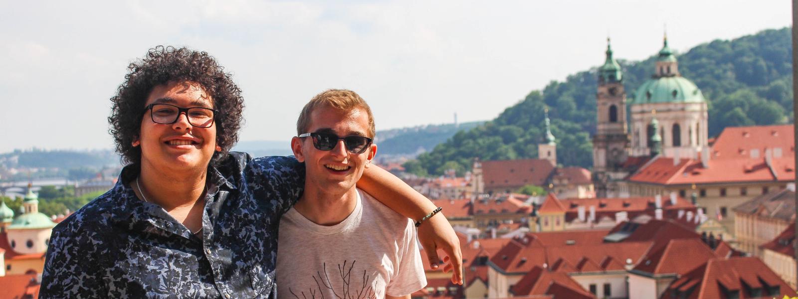 Two students in front of Prague skyline