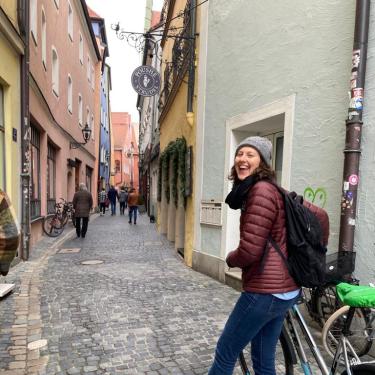 Student pushing a bike down an alley