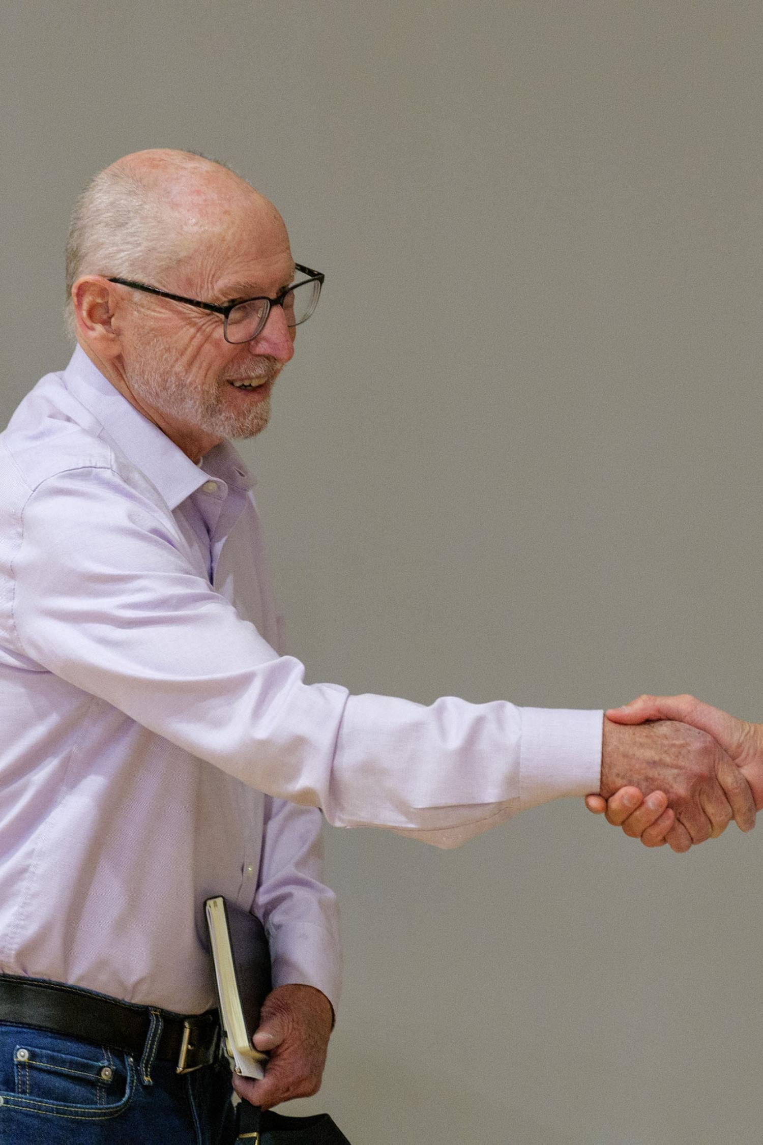 Provost Russ Moore shaking hands with a faculty member during the Faculty of Color celebration