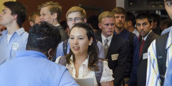 A student talks to an employer at their career fair booth