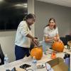 Norah Nyangau and Negar Rahimi carve pumpkins at the October Curci PhD Scholars monthly meeting.