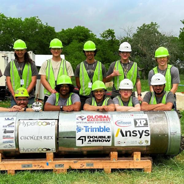 Members of the team with their digging machine at the competition.