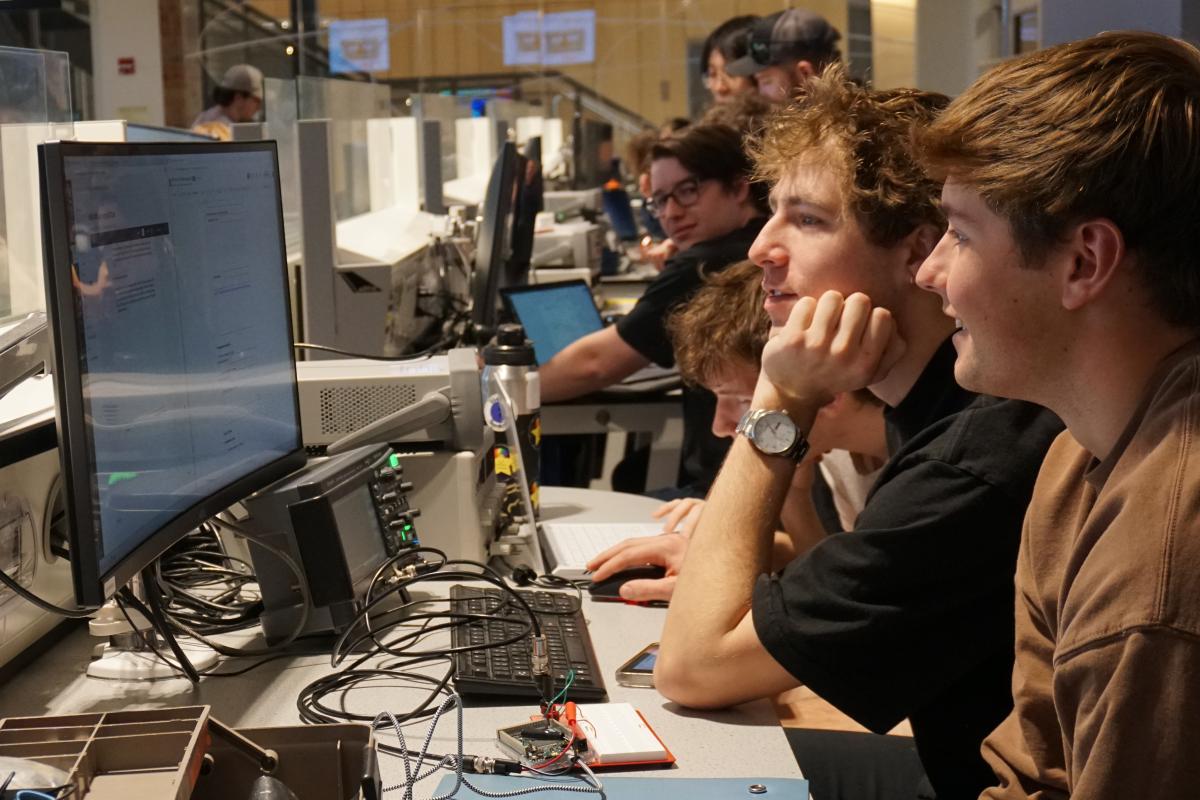 Group of students at a workstation.