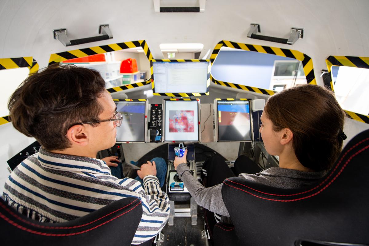 Two students in the Dream Chaser simulator.