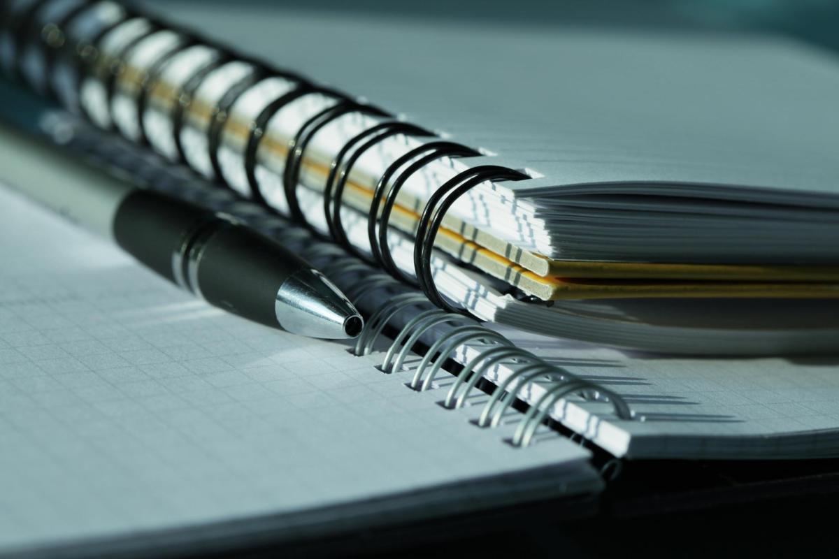 Two notebooks with a pen.