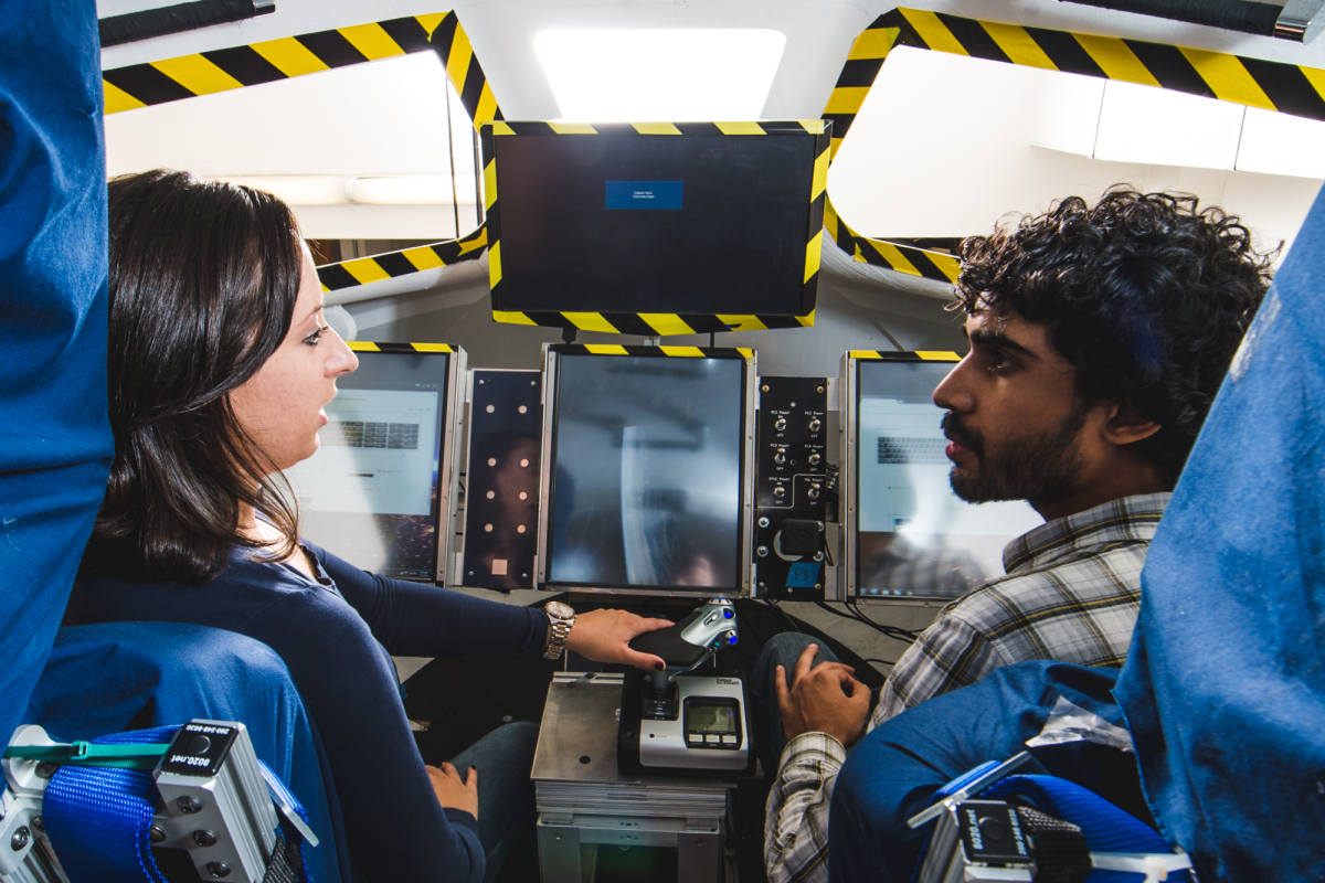 Two students in a flight simulator.