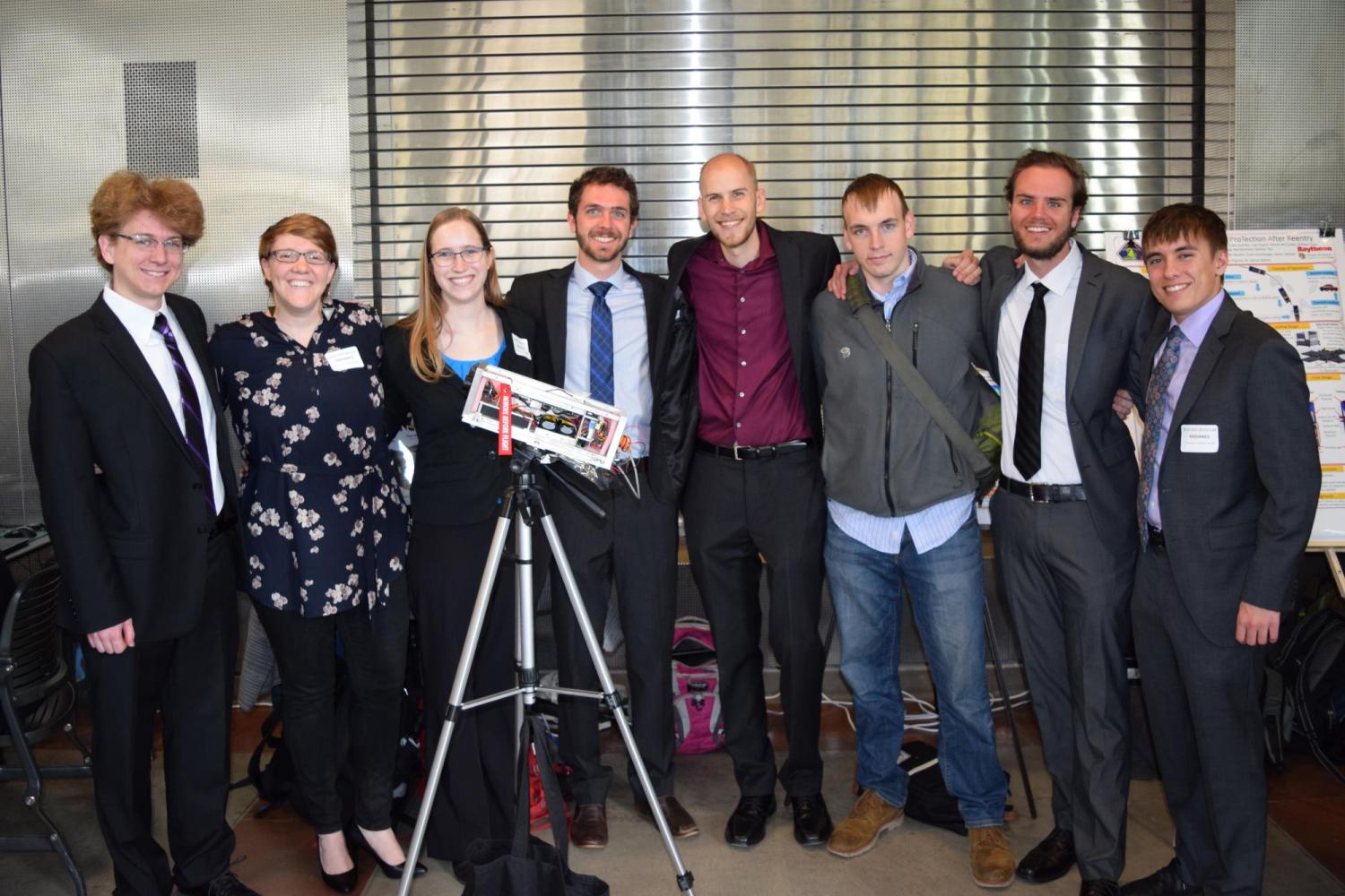 A senior design team with their project.