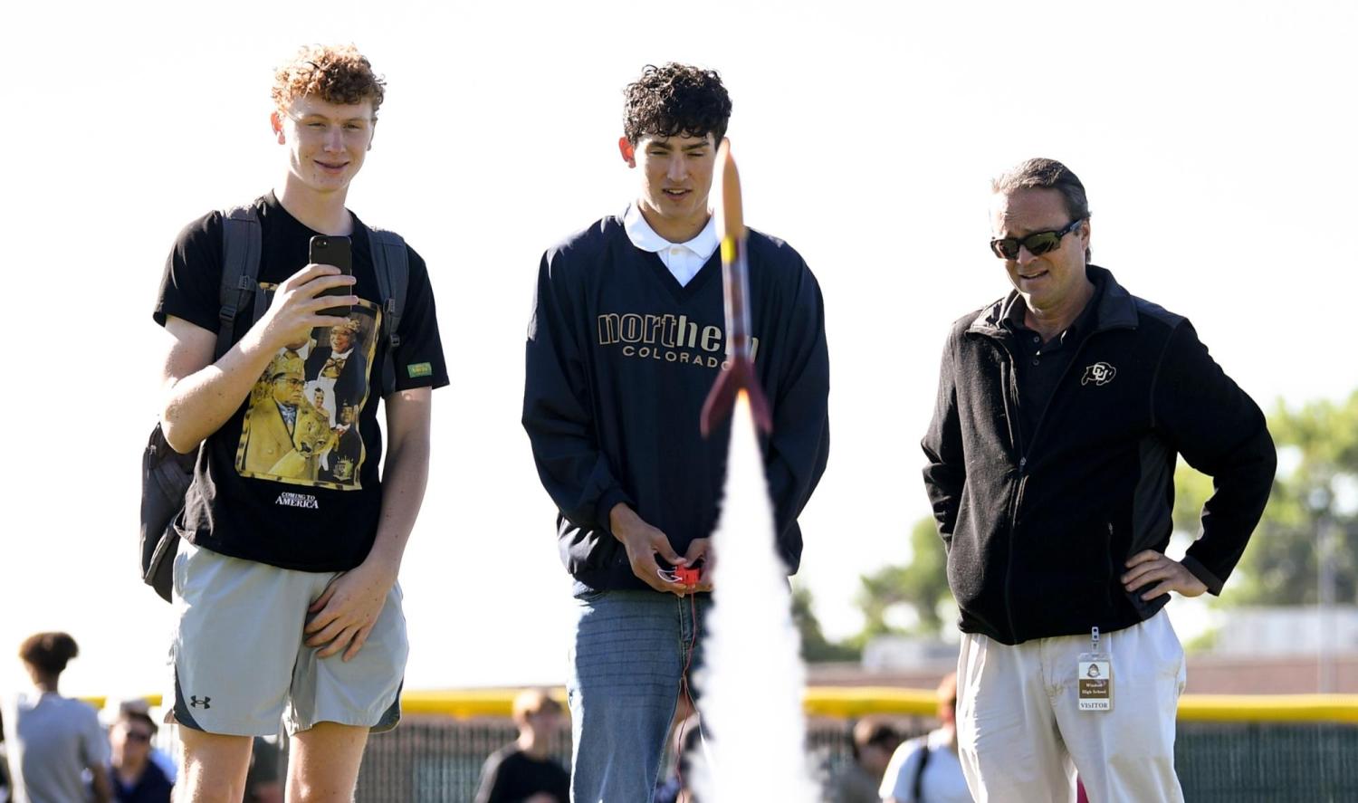 Rhode with two students and a rocket.