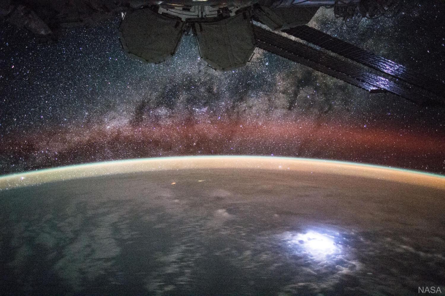 An image taken from the International Space Station shows orange swaths of airglow hovering in Earth’s atmosphere. NASA’s new Atmospheric Waves Experiment will observe this airglow from a perch on the space station to help scientists understand, and ultimately improve forecasts of, space weather changes in the upper atmosphere.