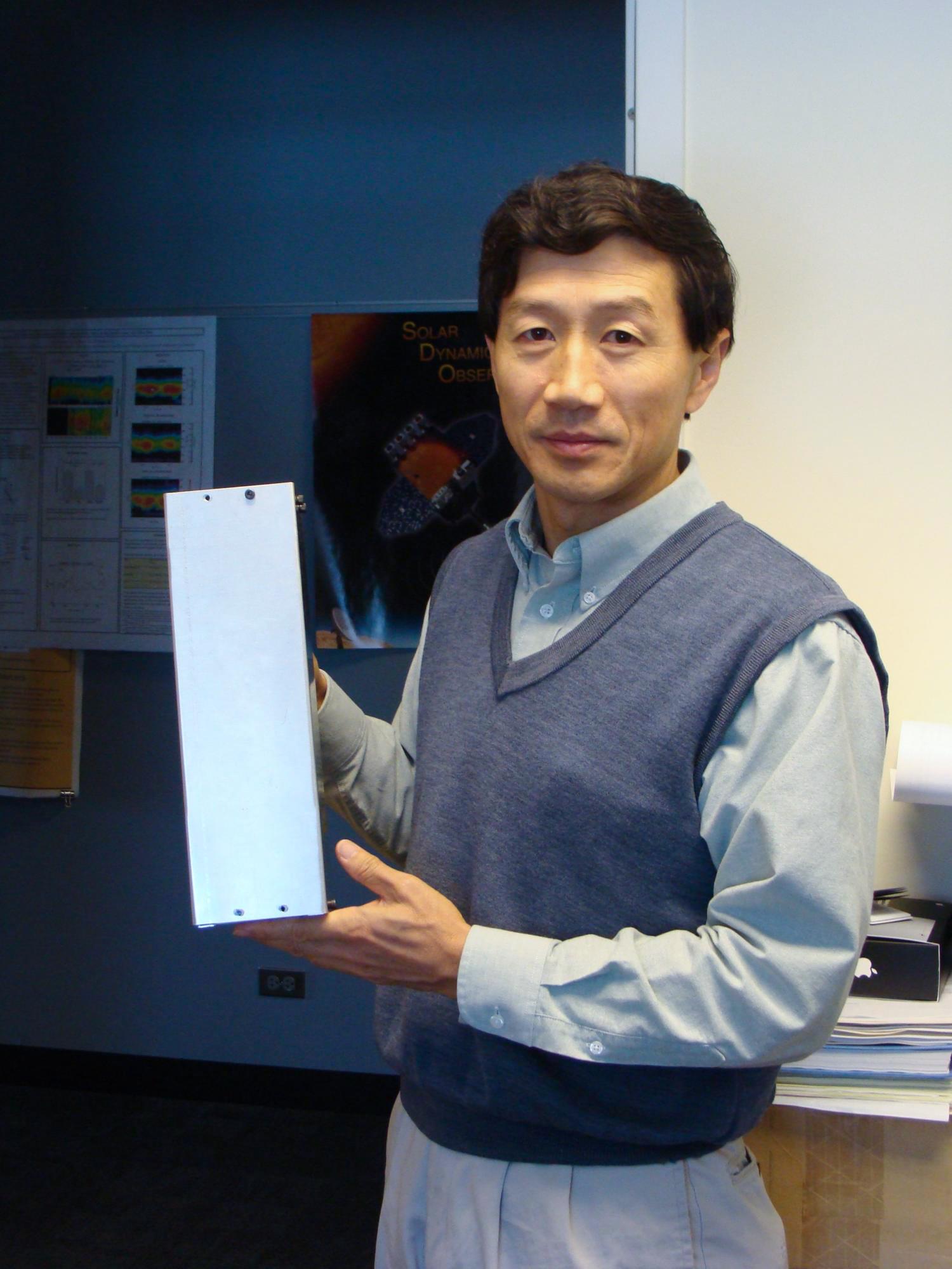 CU Boulder Professor Xinlin Li holds up a model of the CSSWE cube satellite that studied energetic particles in Earth's magnetosphere. The new CIRBE cube satellite will build on the success of the CSSWE. Photo: LASP