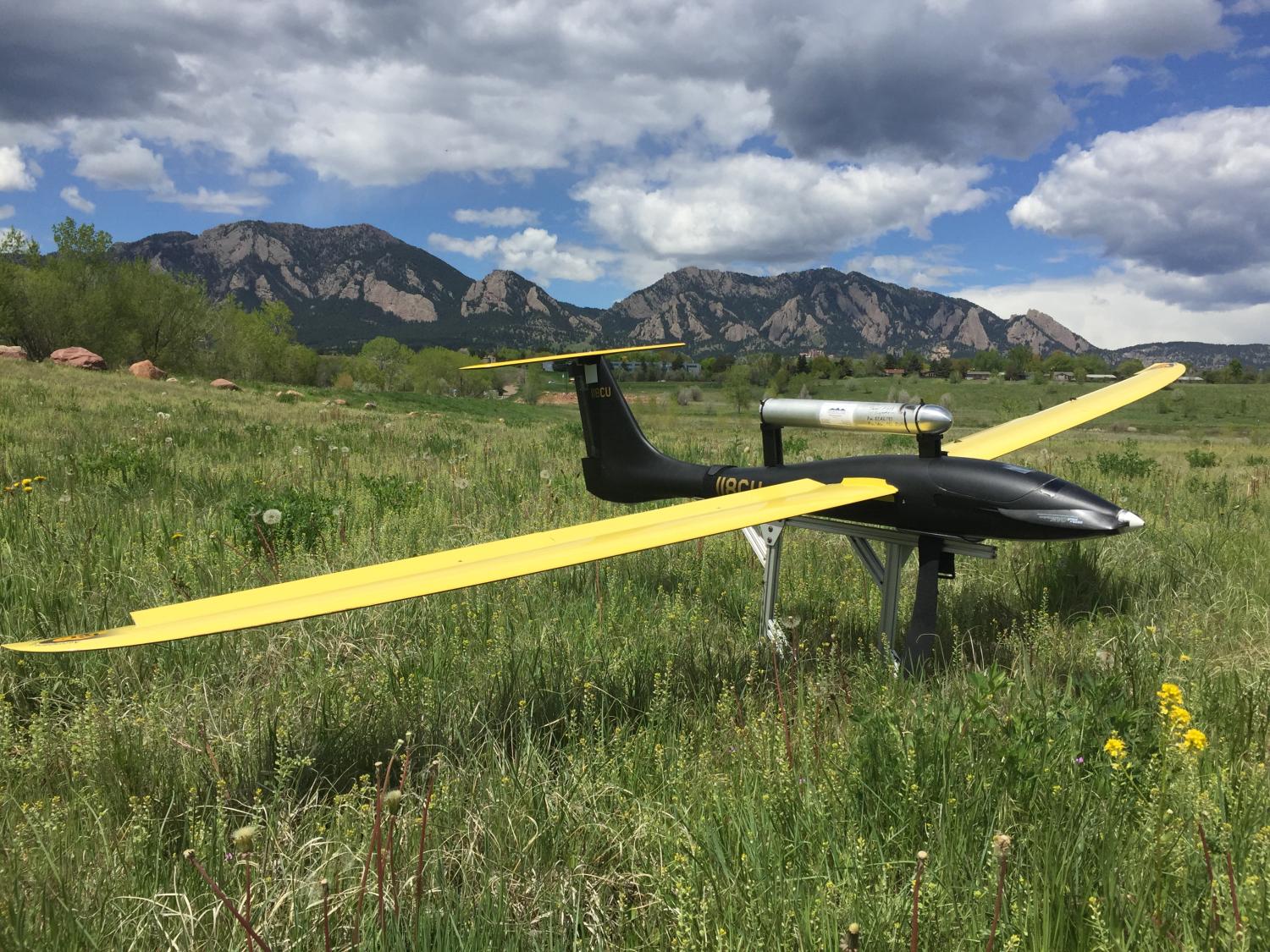 A UAV resting on the ground with the flatirons in the background.