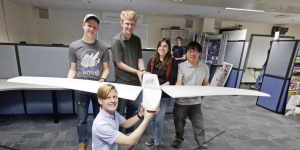 Students holding the drone.
