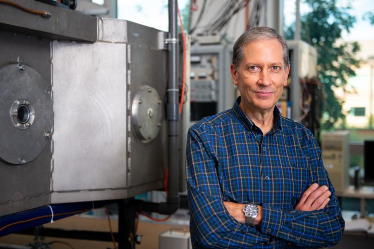 Tim Minton standing by a vacuum chamber in his laboratory.