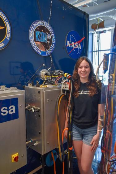 Callie Wynn standing by the bioastronautics tilt translation sled.