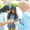 Cawther Rouabhi helping two high school students troubleshoot their camera.