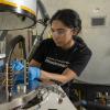 Amrita Singh working with a vacuum chamber.