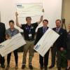 Students from the winning teams with oversized prize checks.