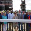 A group of officials standing with the final beam.