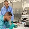 Zea and Niederwieser work on a component in the lab.