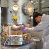 Julian Hammerl makes adjustments to a metal cube representing a derelict spacecraft inside the ECLIPS facility.