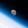 The waning gibbous Moon is pictured above the Earth's horizon as the International Space Station above the Atlantic Ocean.