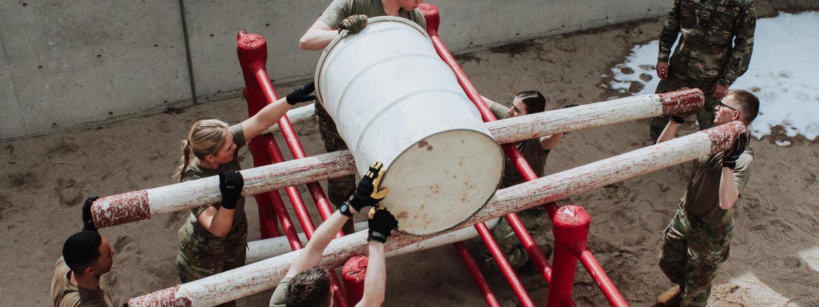 Cadets rolling a barrel in an LRC