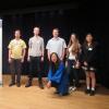 An instructor and some students standing on the stage