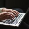 Hands typing on a PC keyboard