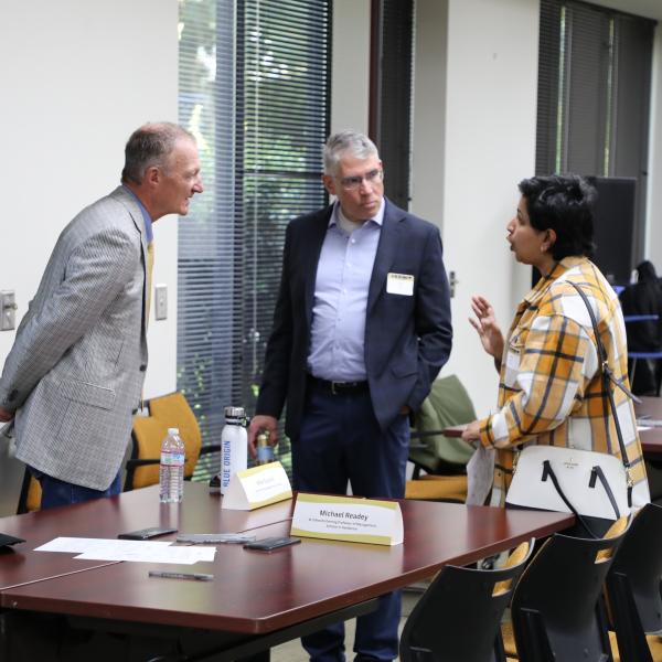 3 people standing in discussion