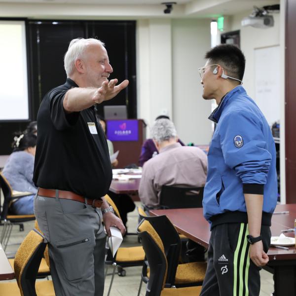 2 people standing, talking