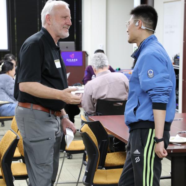 2 people standing, talking
