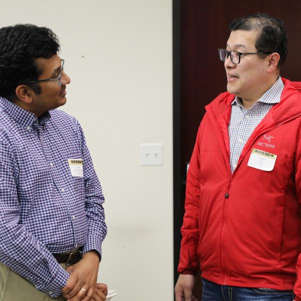2 men standing in discussion