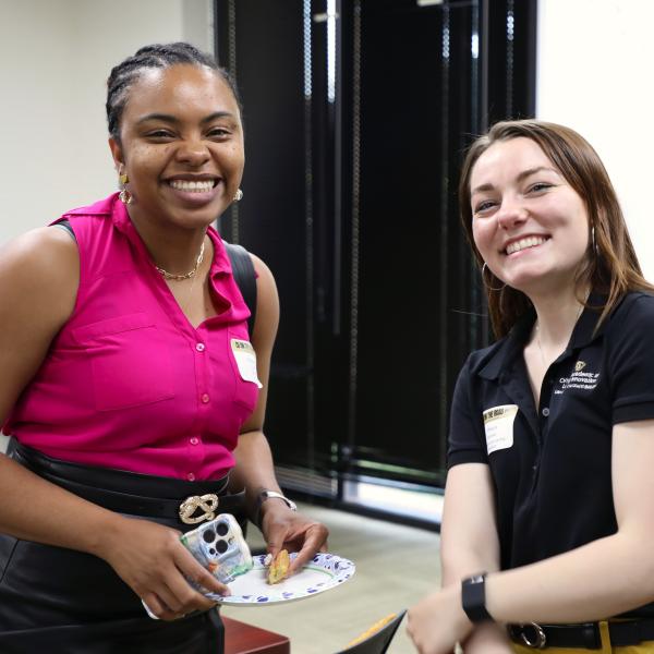 2 people standing and smiling