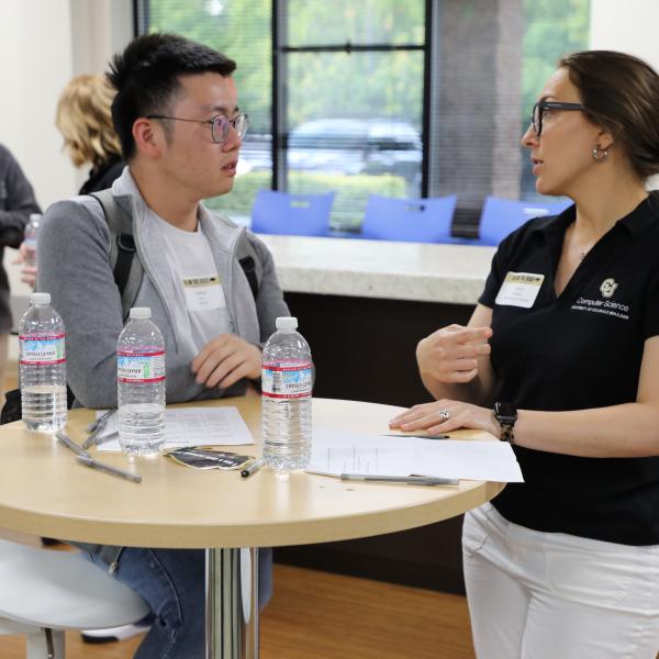 2 people standing, talking