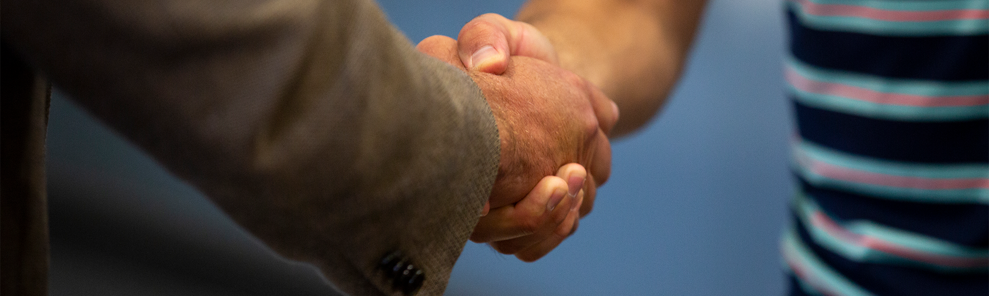 CU Boulder alumni shaking hands