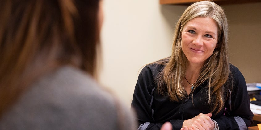 a career services counselor welcoming an alum into their office