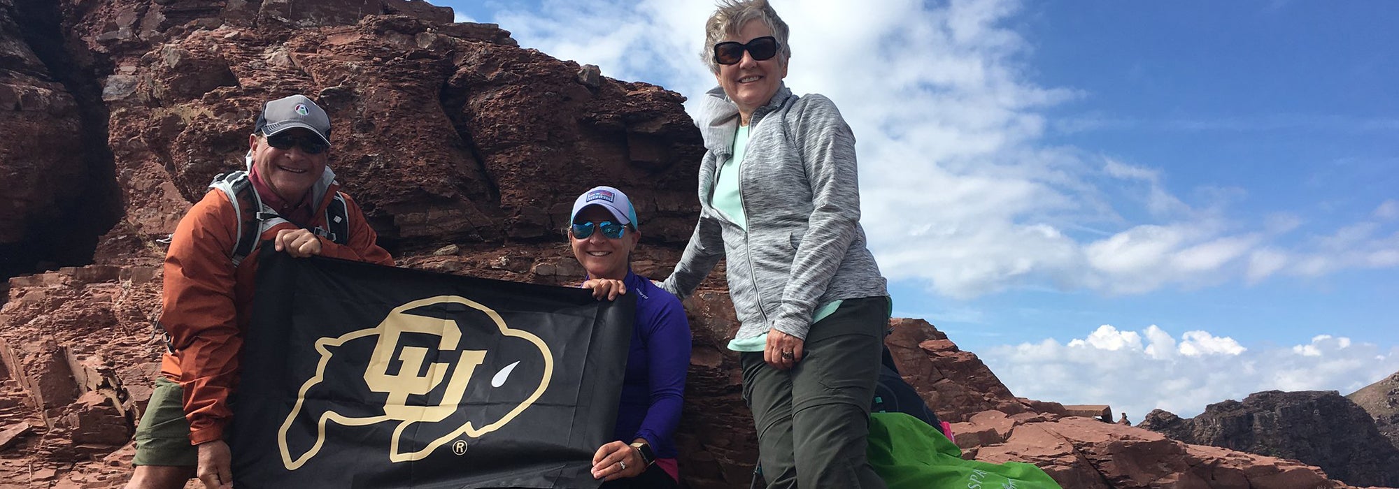 Travelers hold up a CU flag on a Roaming Buffs trips