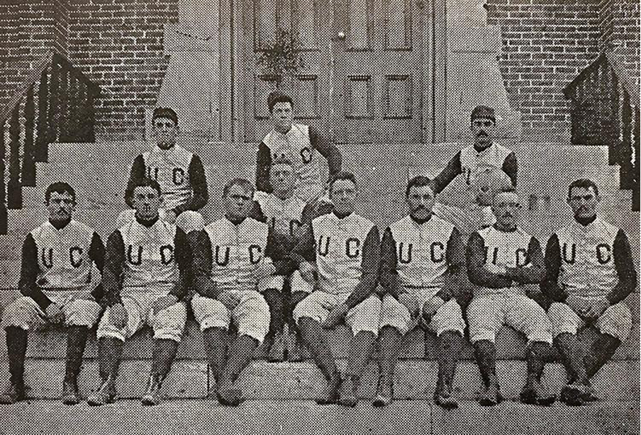 Part of CU's first football team sitting on the steps in front of Old Main