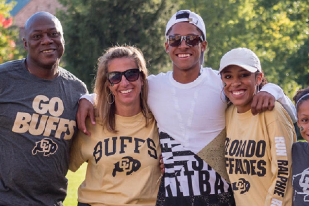 A family of five wearing "go buffs" tshirts stand with their arms around each other