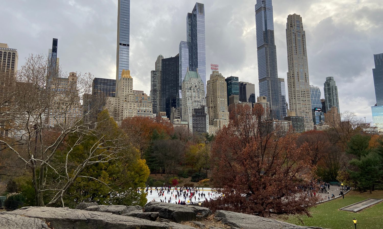 Photograph of Central Park with an ice skating rink visible in the foreground and skyscraper buildings in the background