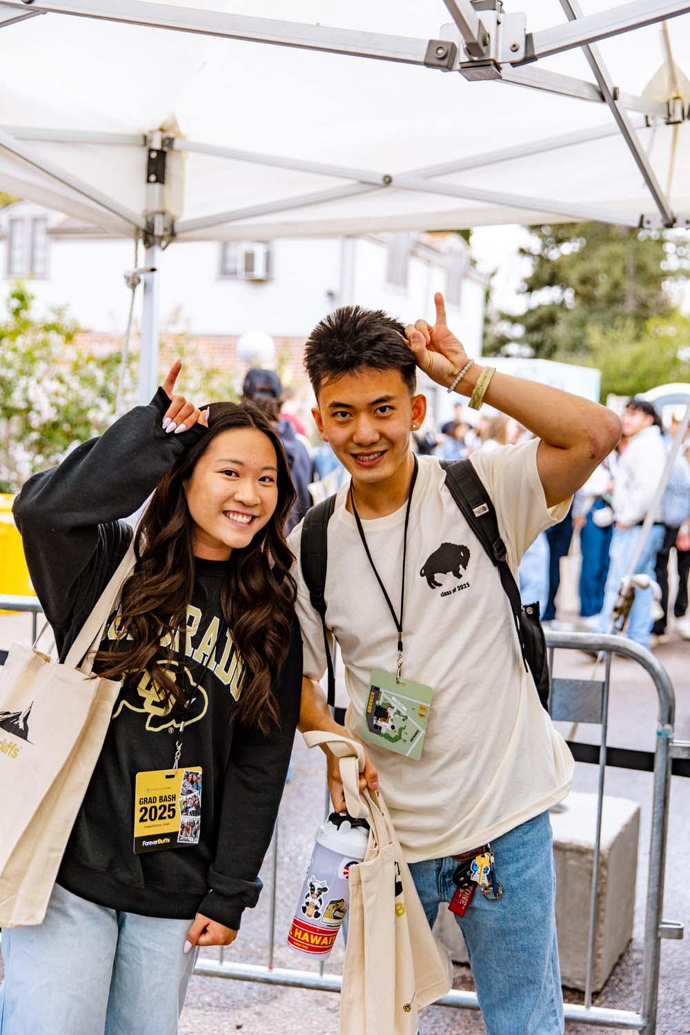 Two CU Boulder students hold up their buffalo horns, a symbol of the CU Boulder buffalo mascot