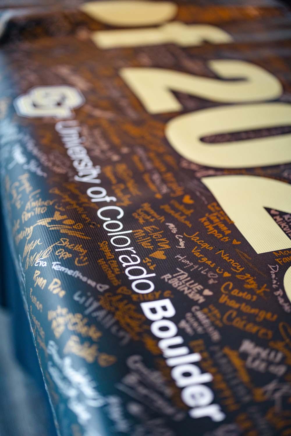 The CU Boulder Class of 2025 banner shows signatures of all students graduating at commencement