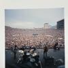 Firefall performing at Folsom Field. The frame looks out onto a crowd of people and the Flatirons are visible in the background.
