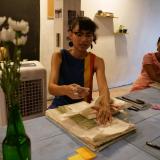 Chu showing how to fold a 8-page zine during the public reading discussion and zine workshop she hosted with Myanmar people in Chiang Mai during her fieldwork in the summer of 2023.